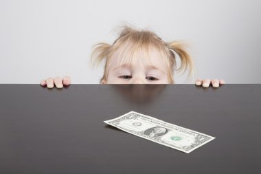baby looking at dollar banknote horizontal clipart