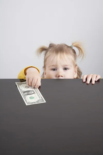 Bebê olhando para câmera tomando dólar — Fotografia de Stock