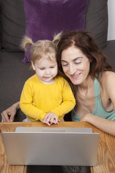 母親と赤ちゃんがコンピューターと笑っています。 — ストック写真