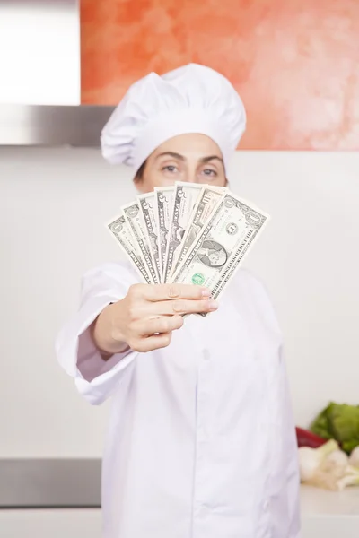 Zwitek banknotów dolara w kobieta kucharz ręcznie — Zdjęcie stockowe