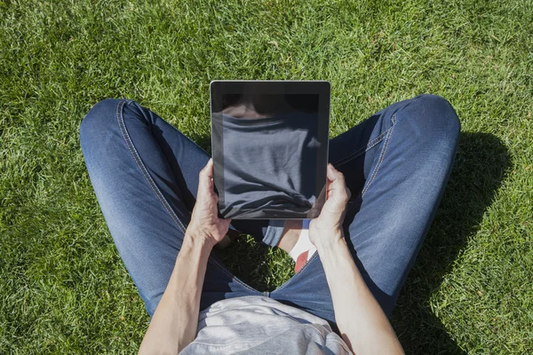Mulher perneira na grama com tablet — Fotografia de Stock