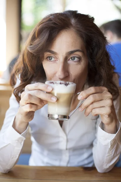 Frau trinkt Cappuccino-Kaffee — Stockfoto