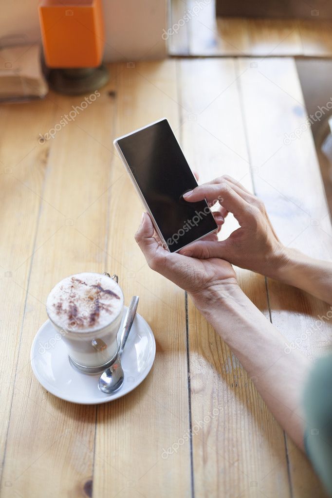 woman using blank phone in cafe