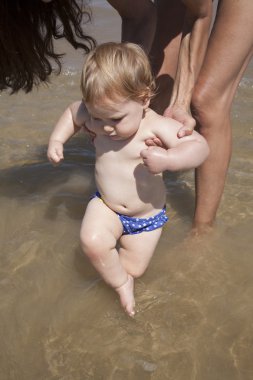 baby and mother bathing in the ocean