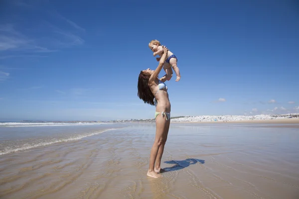 Bébé volant dans les bras de la femme à côté de Conil — Photo