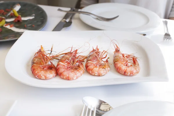 Quatro deliciosos camarões grandes na bandeja branca — Fotografia de Stock