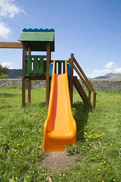 Orange slide in grass — 스톡 사진