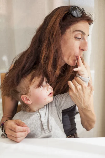 Mulher chupando bebê dedo chocolate — Fotografia de Stock