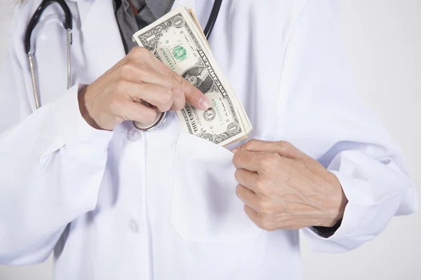 Doktor zasunutí balík dolarů v kapse — Stock fotografie