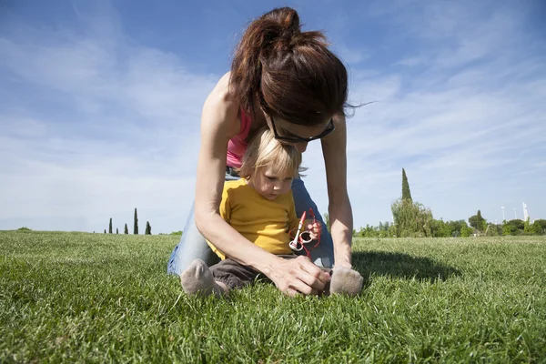 Mother tying her daughter shoes — Stock Photo, Image