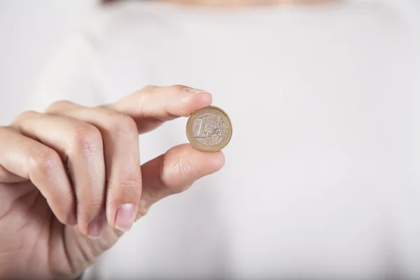 Frauenhand zeigt abgenutzte Euromünze — Stockfoto