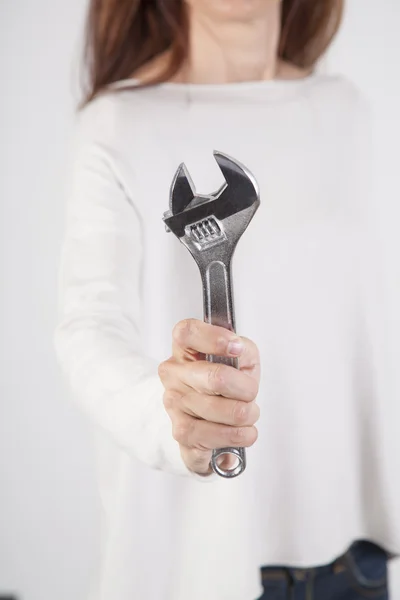 Llave inglesa en mano de mujer — Foto de Stock