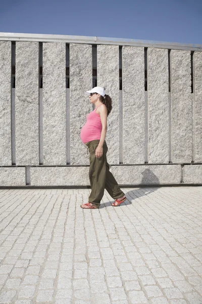 Rosa embarazada caminando pared de granito —  Fotos de Stock