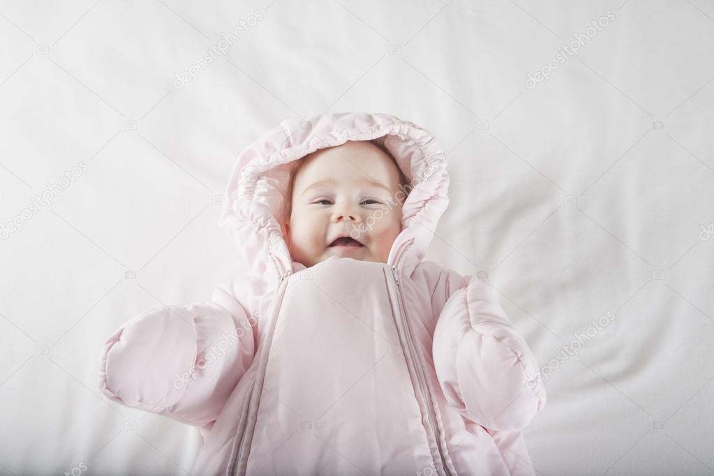 smiling baby face wrapped in pink snowsuit
