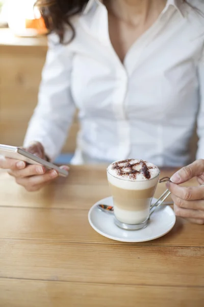 Frau benutzt Handy in Café — Stockfoto