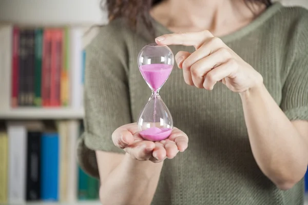 Woman with pink sand clock — 图库照片