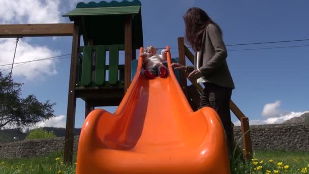 Baby slithering on orange slide — Stock Video