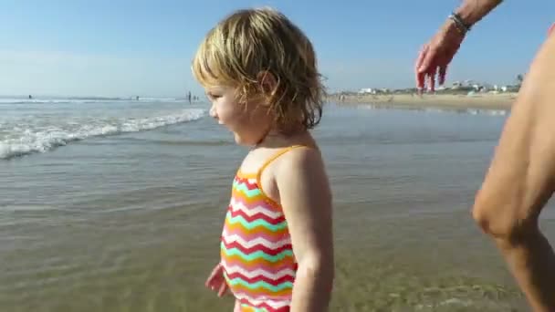 Baby walking ocean holding mom hands — Stock Video