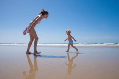 deniz kıyısı ve anne mutlu bebek