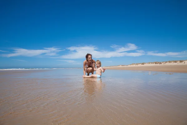 Donna e bambino seduti a riva — Foto Stock