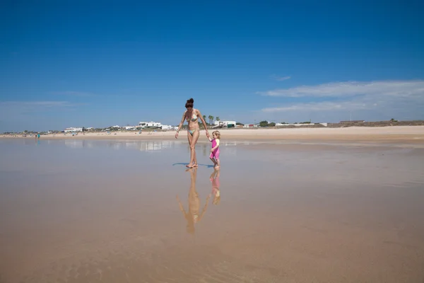 Mulher e bebê andando na costa — Fotografia de Stock