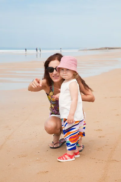Mère pointant avec bébé à la plage — Photo