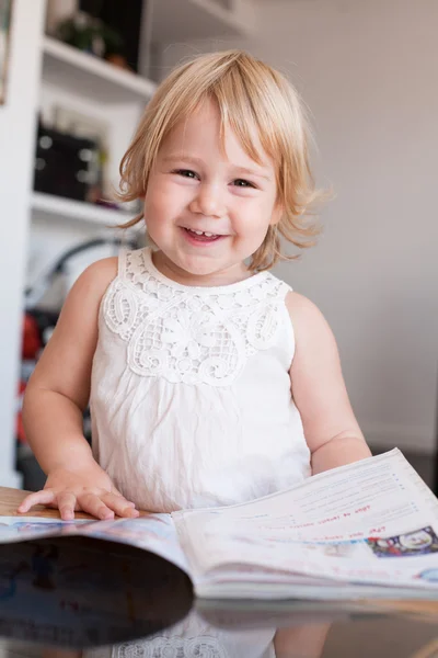 Sorridente baby thumbing magazine — Foto Stock