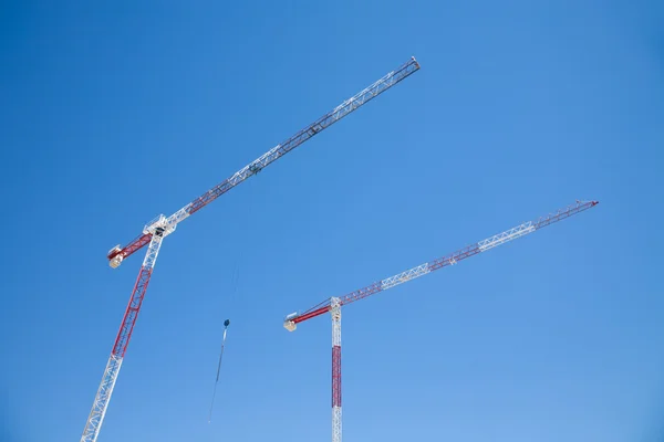 Dois guindastes no céu azul — Fotografia de Stock