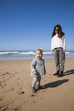 Bebek ve anne kameraya bakarak Beach