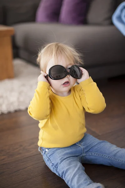 Ребенок играет со взрослыми солнцезащитными очками — стоковое фото