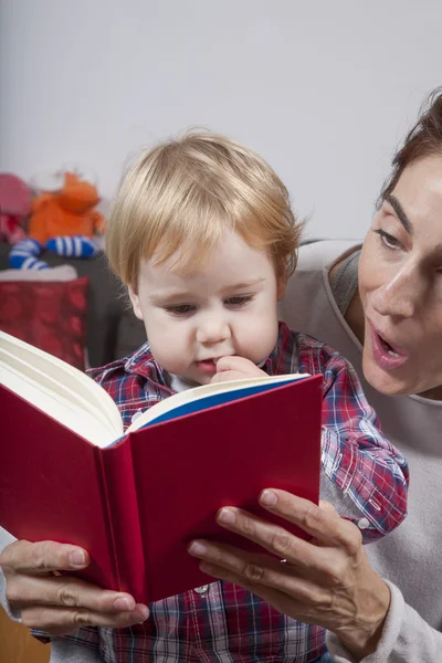 Bebê e mãe lendo livro vermelho — Fotografia de Stock