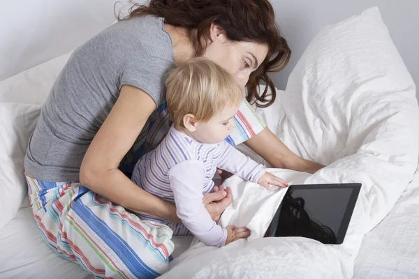 Family and tablet on bedcover — Stock Photo, Image