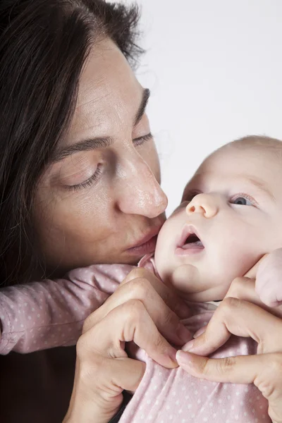 Mama küsst Baby rosa onesie — Stockfoto