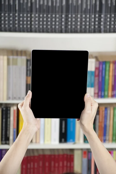 Hands tablet aanduiding over bibliotheek — Stockfoto