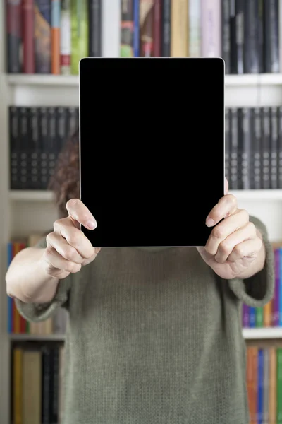 Frau zeigt Tablet in Bibliothek — Stockfoto