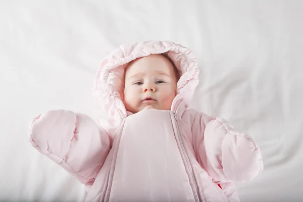 Gezicht van de baby verpakt in roze snowsuit — Stockfoto