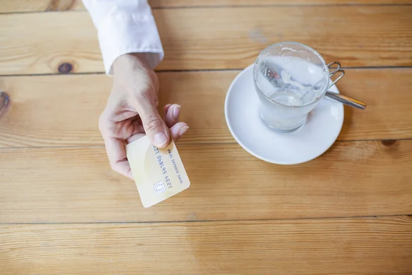 Mano con tarjeta de crédito para pagar en la cafetería — Foto de Stock