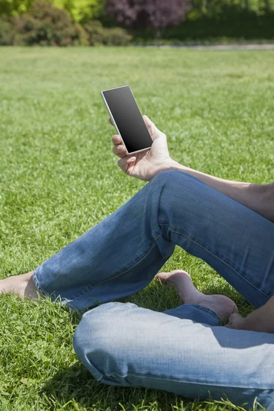 Teléfono en blanco en la mano de la mujer descalza — Foto de Stock