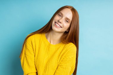 Kameraya bakıp gülümseyen mutlu kızıl kız.