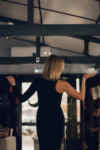 Atrás Mujer Vestido Negro Sosteniendo Una Taza Restaurante Cafetería Conceptos —  Fotos de Stock