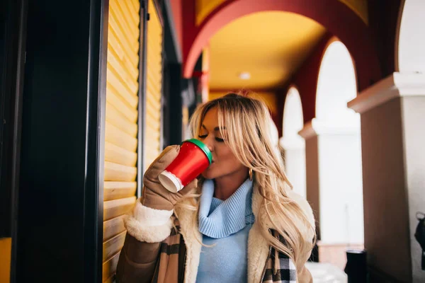 Wanita Tersenyum Berjalan Jalan Selama Salju Memegang Secangkir Kopi Mengenakan Stok Foto Bebas Royalti