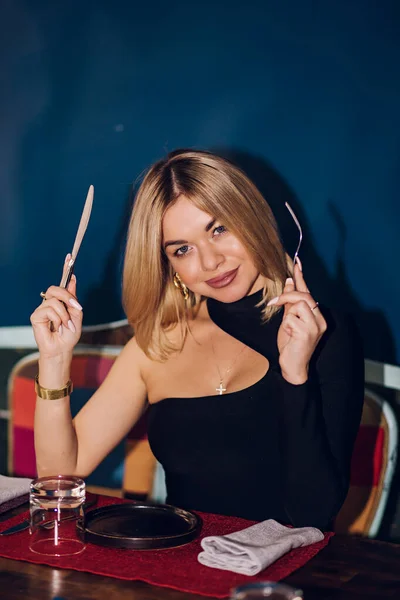 Woman Holds Fork Knife Table Restaurant Blonde Girl Wearing Black — Foto Stock