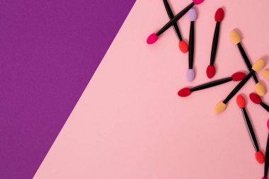 Bir sürü aplikatör, renkli ve parlak arkaplanlı göz fırçaları ve fotokopi alanı. Profesyonel makyaj, kozmetik, güzellik, bakım konsepti