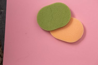 Pembe arka planda iki güzel yeşil ve sarı makyaj süngeri fotokopi alanı ile