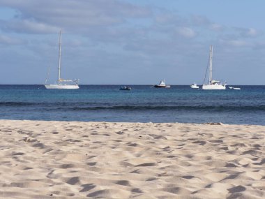 Atlantik Okyanusu 'ndaki beyaz yatlar Cape Verde' deki Afrika Sal Adası 'ndaki manzaralar, ufuk çizgisi ve 2019 Mart ayındaki sıcak yaz gününde açık mavi gökyüzü..