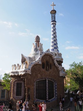 İspanya 'nın Katalonya bölgesindeki Barselona şehrindeki Guell Parkı' nda bir ev, Eylül 'ün sıcak ve güneşli bir yaz gününde açık mavi bir gökyüzü - dikey