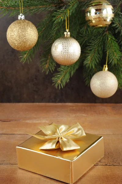 Brunch of xmas tree with color balls and golden gift box — Stock Photo, Image