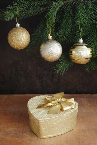 Brunch of xmas tree with color balls and golden gift box — Stock Photo, Image