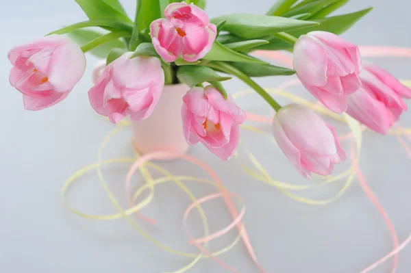 Belas tulipas rosa em um vaso com papel decorativo — Fotografia de Stock