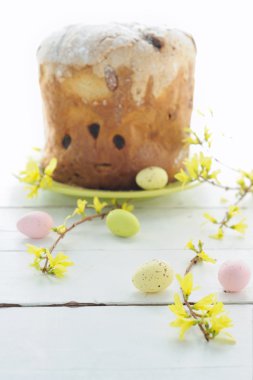 Paskalya yumurtaları, tatil pasta ve çiçekli dallar üzerinde ahşap masa